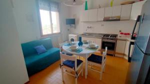 a kitchen with a table and chairs and a kitchen with a refrigerator at BILOCALE IN PIAZZA A NUMANA VISTA MARE BELLISSIMA - cod 485 in Numana