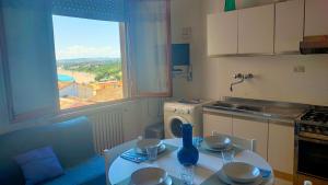 a kitchen with a table and a window with a view at BILOCALE IN PIAZZA A NUMANA VISTA MARE BELLISSIMA - cod 485 in Numana