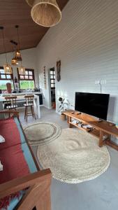a living room with a couch and a table at Vila do Sussurro - Casinha Céu in Triunfo