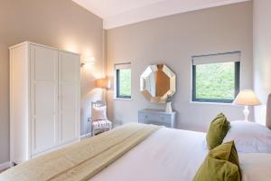 a bedroom with a large white bed and a mirror at Charlie in Richmond