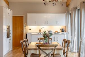 a kitchen with a table and a kitchen with white cabinets at Charlie in Richmond +11 photos