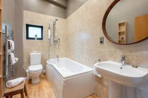 a bathroom with a sink and a tub and a toilet at Finley in Richmond +16 photos