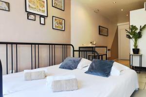 a bedroom with a white bed with blue pillows on it at Modern in Bègles