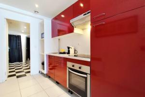 a kitchen with red cabinets and a red wall at Modern in Bègles