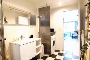 a bathroom with a sink and a washing machine at Modern in Bègles +4 photos
