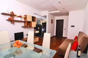 a dining room and living room with a glass table at Harmony Residence in Bucharest