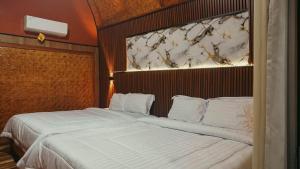 a bedroom with a large bed with white pillows at Angghy Garden Tetebatu in Tetebatu