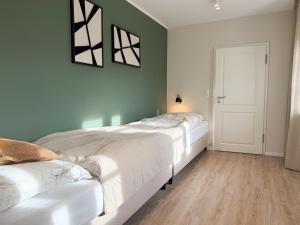 a bedroom with two beds and a door at Alte Wassermühle Nord in Börm