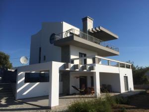 a white house with a balcony on top of it at Villa Chiara in Limenaria