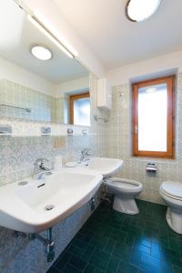 bagno con 2 lavandini e servizi igienici di Villa Marilena a Livigno