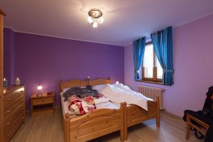 リヴィーニョにあるVilla Marilenaの紫の壁のベッドルーム1室、ベッド1台(ぬいぐるみの動物付)