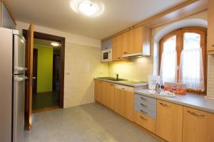 una cucina con armadi in legno e frigorifero in acciaio inossidabile di Villa Marilena a Livigno