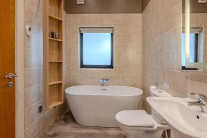 a bathroom with a tub and a sink and a toilet at Flora in Richmond +14 photos