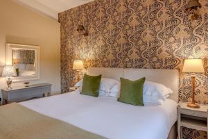 a bedroom with a large white bed with green pillows at Flora in Richmond
