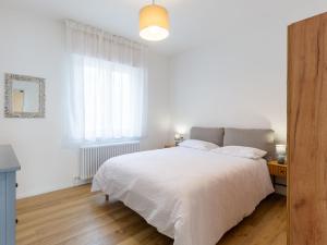 a white bedroom with a bed and a window at Apartment Lago di Luce by Interhome in Riva del Garda