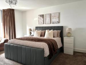a bedroom with a large bed with a gray headboard at Holdsworth House Apartments in Killingbeck