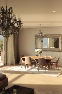 a dining room with a table and chairs and a chandelier at Casa La Perla in Budva