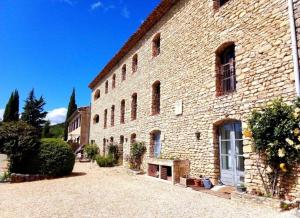 a large brick building with a bench in front of it at Charmant studio à Viens in Viens