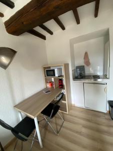 a kitchen with a table and chairs in a room at Charmant studio à Viens in Viens