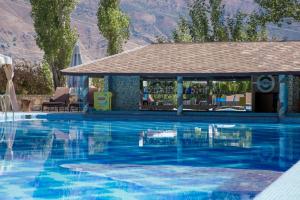 a swimming pool with a gazebo next to a mountain at Avenue Park Hotel in Yusufkhona