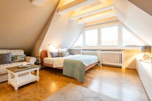 a attic bedroom with a bed and a couch at Princessa Coast in Süderende