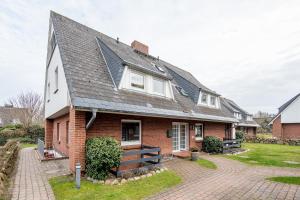 a red brick house with a gray roof at Princessa Coast in Süderende