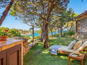 a garden with a bed and a view of the water at Apartment Mare 8 by Interhome in Porto Cervo