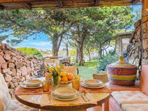 a table with a bowl of fruit on a patio at Apartment Mare 8 by Interhome in Porto Cervo +22 photos