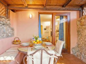 a table and chairs in a room with a stone wall at Apartment Mare 8 by Interhome in Porto Cervo