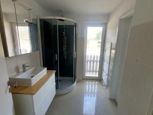 a bathroom with a glass shower and a sink at Seeluft in Warin +21 photos