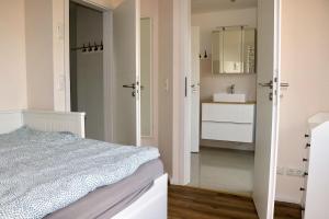 a white bedroom with a bed and a sink at Seeluft in Warin