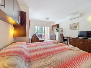 a bedroom with a large bed and a kitchen at Studio Rilić-1 by Interhome in Zaostrog
