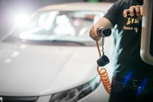 a man holding a phone next to a white car at GreenStar Hotel Joensuu in Joensuu