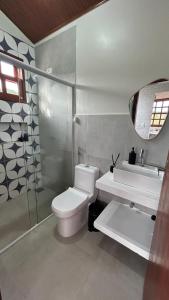 a bathroom with a toilet and a sink and a mirror at Vila do Sussurro - Casinha Céu in Triunfo +14 photos