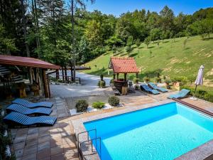 a swimming pool with chairs and a gazebo at Chalet Pine Hill by Interhome in Klenovnik +42 photos