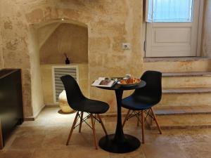 a table and two chairs in a room with stairs at Dimore dei Mercanti in Matera