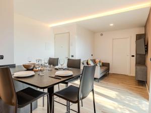 a dining room with a table and chairs and a couch at Apartment Garda Oasis by Interhome in Riva del Garda +37 photos