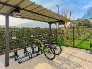 a green bike parked under a canopy at Apartment Garda Oasis by Interhome in Riva del Garda