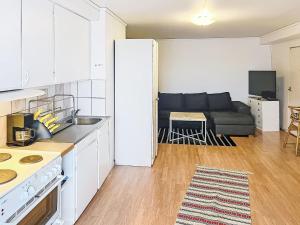 a kitchen and a living room with a couch at Apartment Stadsro by Interhome in Vimmerby +8 photos