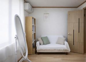 a white couch in a room with a mirror at MAMA Alice in Seoul