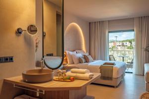 a bedroom with a bed and a bathroom with a sink at Zeus Eleva Kassandra Lagoon in Hanioti +103 photos