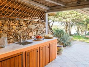 a kitchen with a sink and a stone wall at Apartment Vista 9 by Interhome in Porto Cervo
