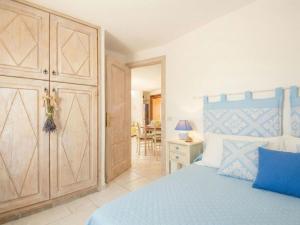a bedroom with a blue bed with a wooden cabinet at Apartment Vista 9 by Interhome in Porto Cervo