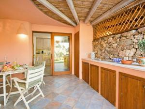 a kitchen with a table and a stone wall at Apartment Vista 9 by Interhome in Porto Cervo +23 photos