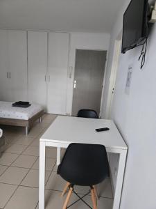 a room with a white desk and two chairs at Studio 110 pres Basel Airport in Saint-Louis