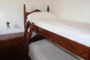 a bunk bed with white sheets and a wooden frame at Residence Hotel Torresilvana in Vieste