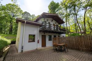 a small house with a balcony and a table at Arsenal Park Transilvania in Orăştie