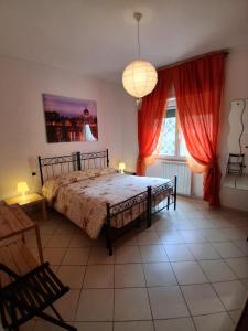 a bedroom with a large bed with red curtains at B&B Salviani in Acilia +17 photos