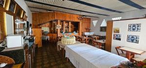 a dining room with a table and some tables and chairs at Pousada Hotel Casarão SerraNegra in Serra Negra