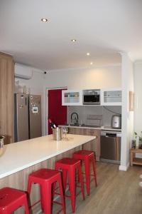 a kitchen with red stools and a counter in a kitchen at Logans Place in Oakdale